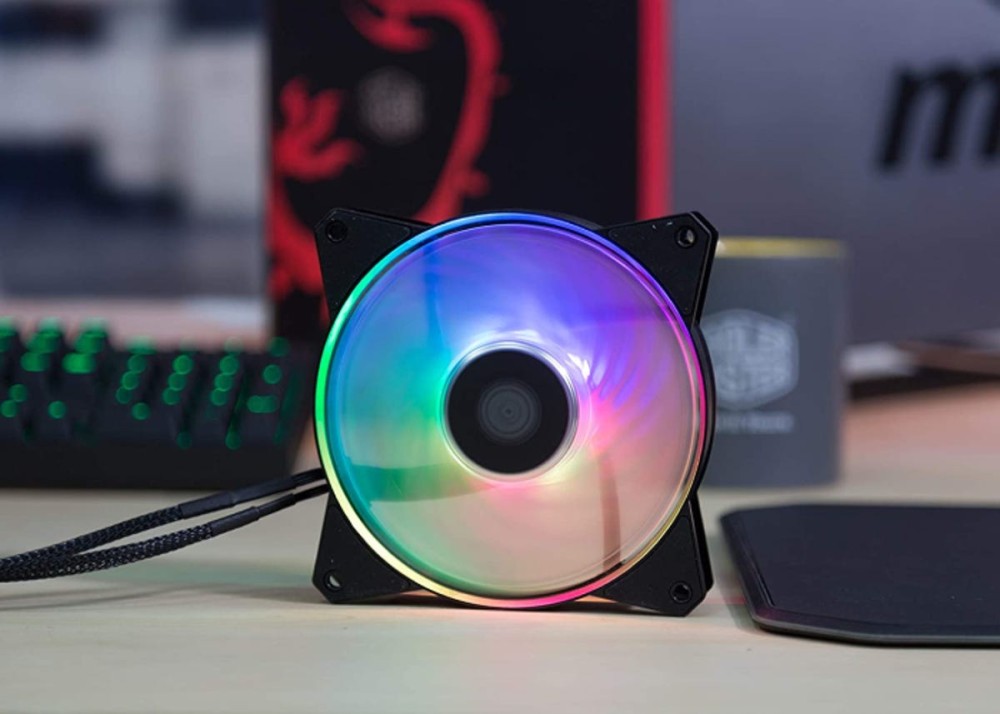 rainbow RBG fan on a desk in front of a keyboard