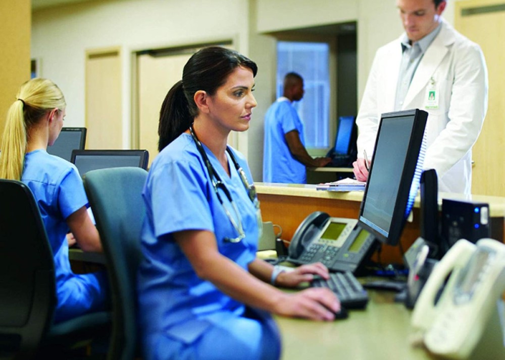 nurse using a computer with a privacy screen