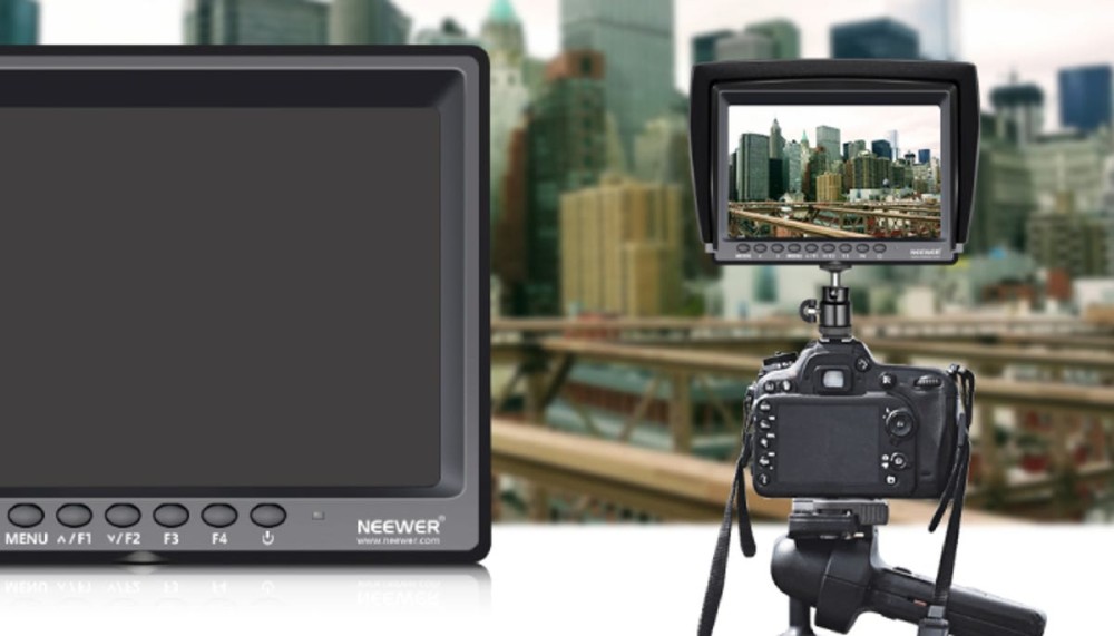 a monitor over a camera showing the city scape in the background