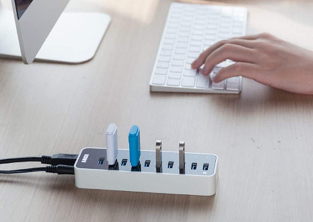 Person typing on USB keyboard with a USB hub plugged into a computer