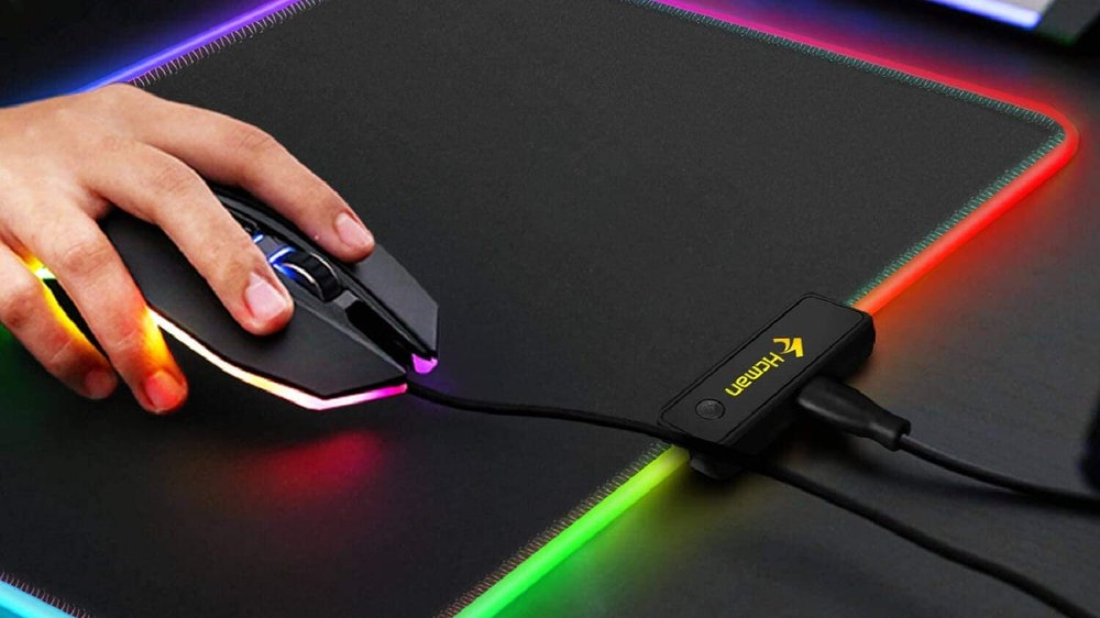 A person uses a mouse on an RGB mouse pad.