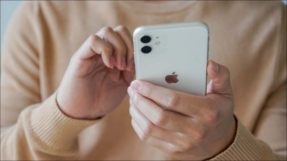 Closeup of a man's hands holding an iPhone 11.