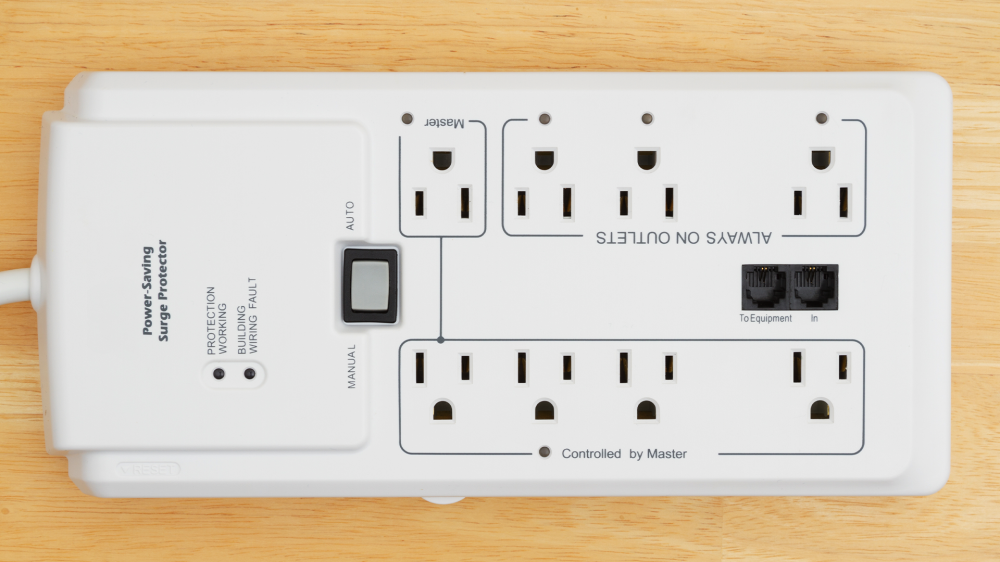 A big white surge protector on a wooden floor.