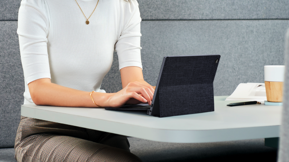 Someone typing on the ASUS ExpertBook B3 Detachable at a table. It's very compact!