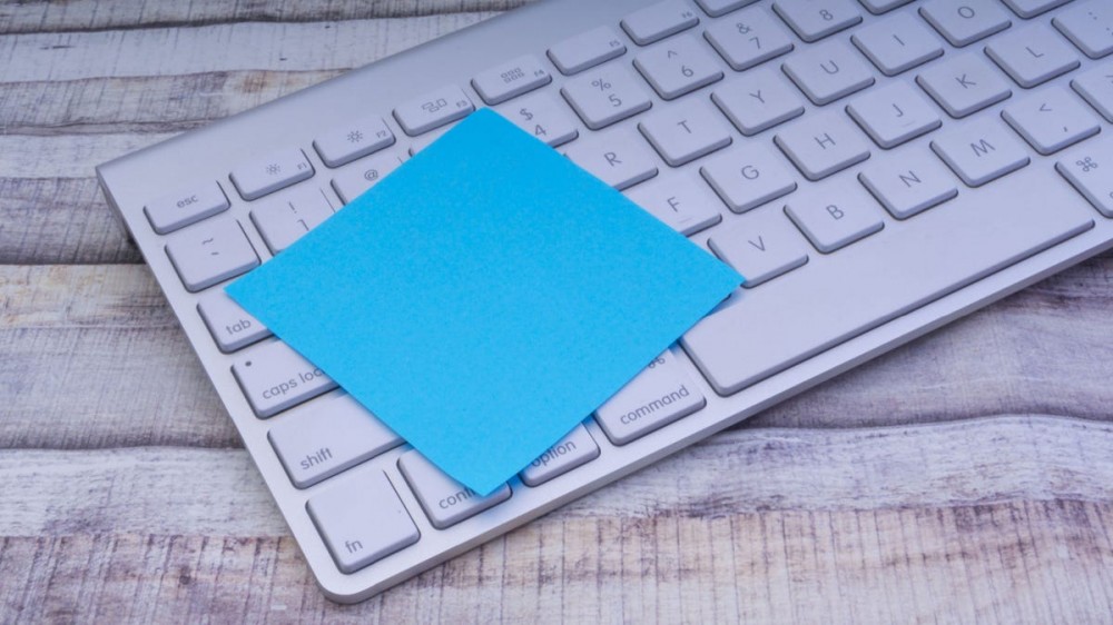 Closeup of colorful sticky post note on a office computer keyboard.