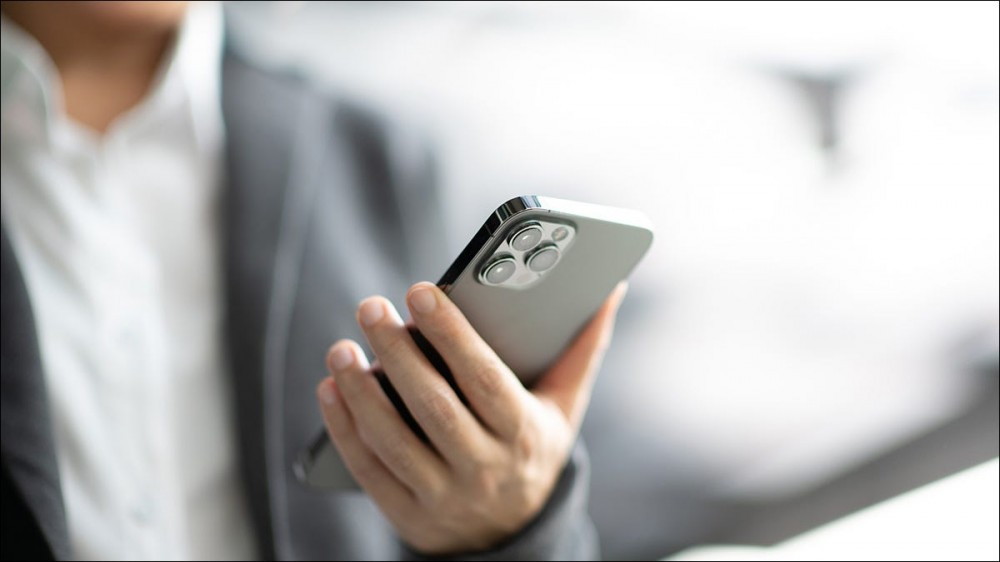 A businessperson holding an iPhone.