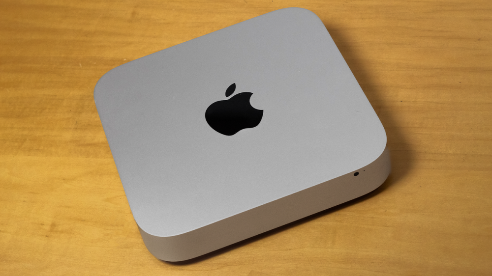 The Mac mini on a wooden desk.