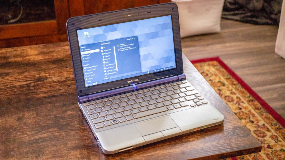 A Toshiba Netbook sitting on a table with the menu open