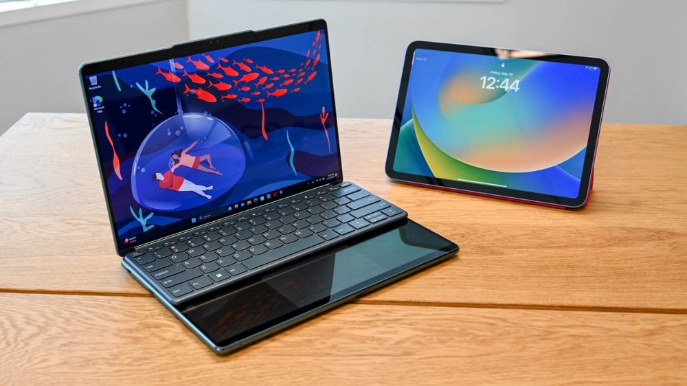 The Lenovo Yoga Book 9i next to an iPad