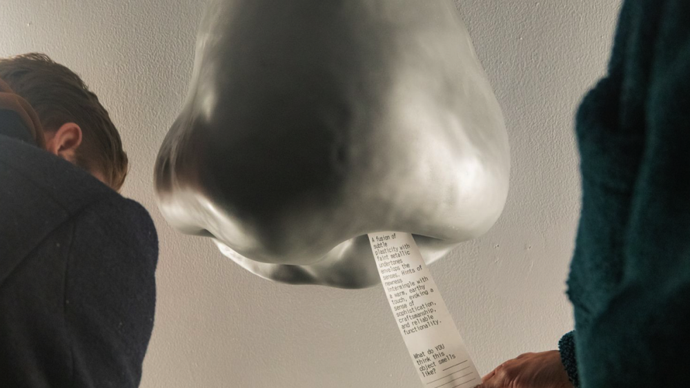 Sculpture of a nose with a receipt coming out of its nostril.