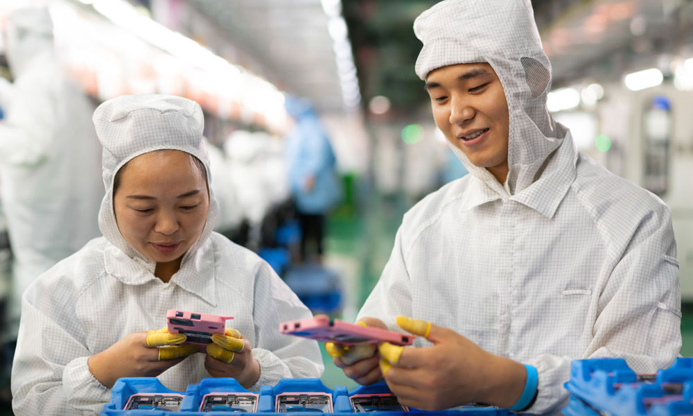 Chinese factory workers inspecting rear iPhone casings