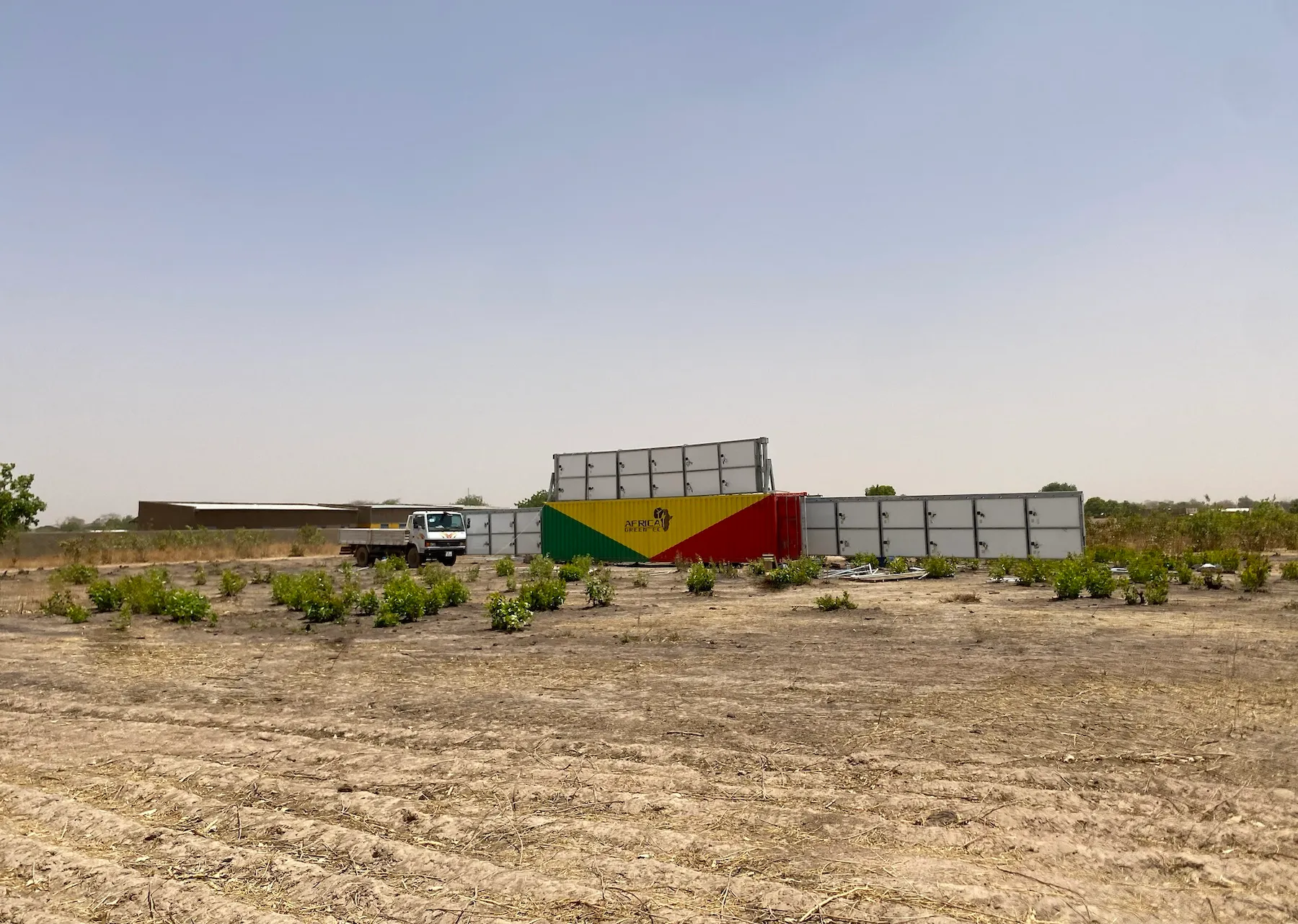 a shipping container surrounded by solar panels in desolate area