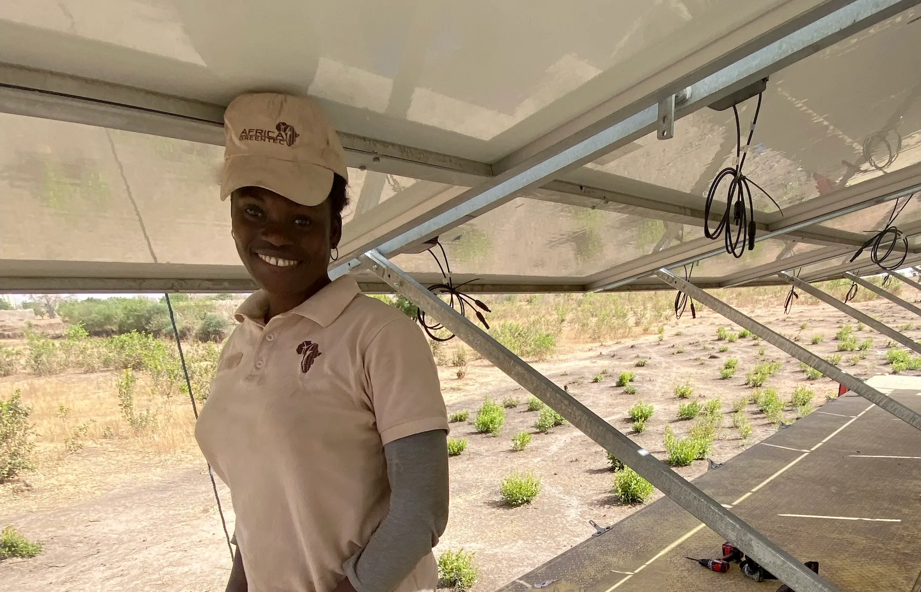 a woman stands under solar panels