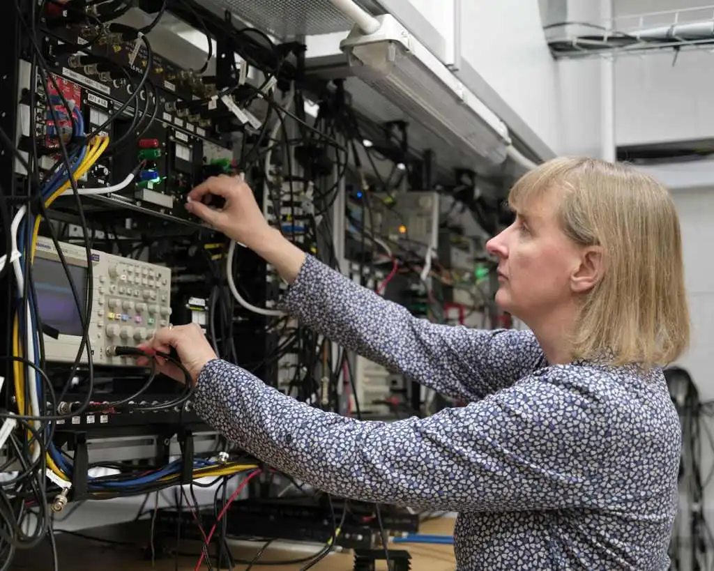 a woman adjusts knobs and wires