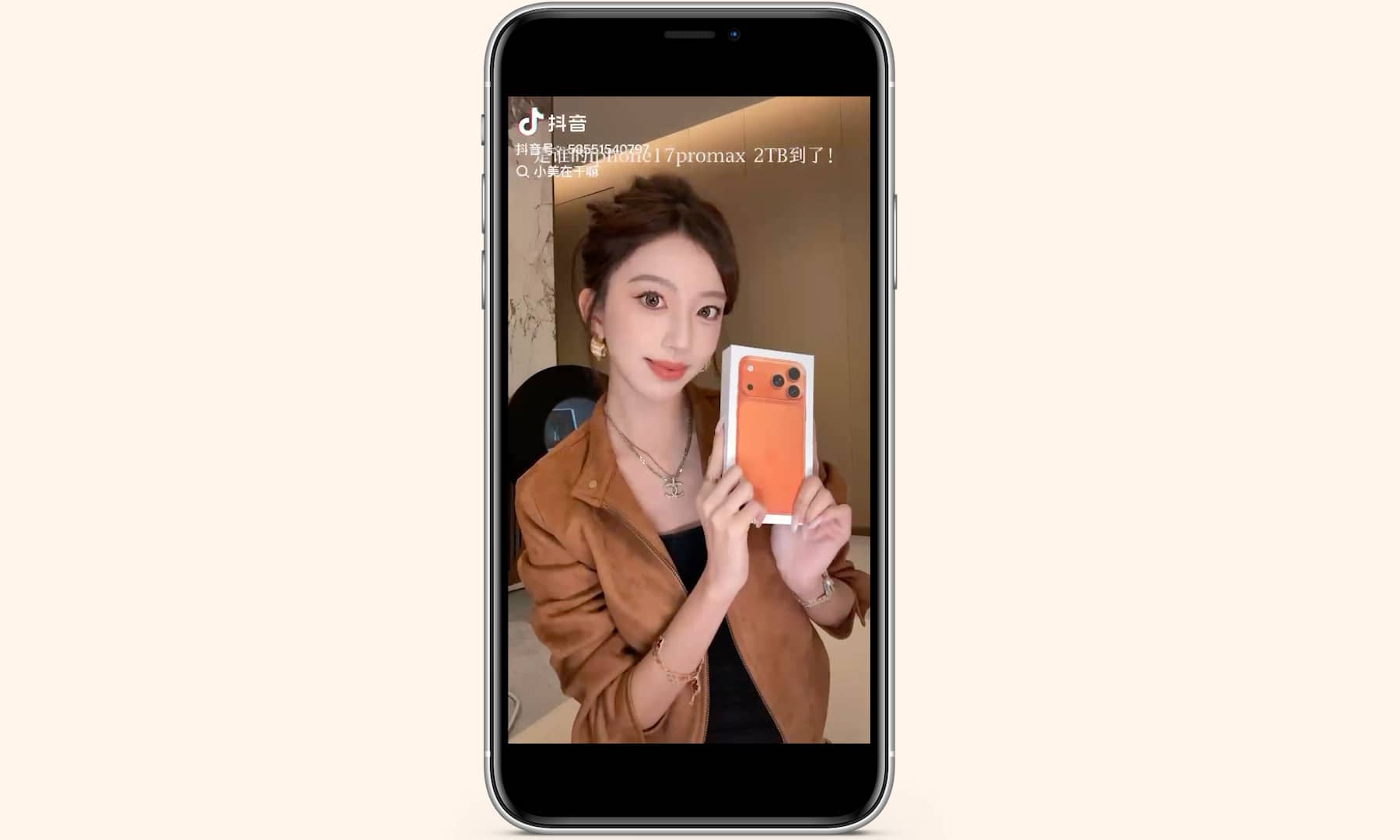 A screenshot from a viral social media video showing influencer Xiao Mei posing with a vibrant Cosmic Orange iPhone 17 Pro, which she compares to the signature color of luxury brand Hermès.